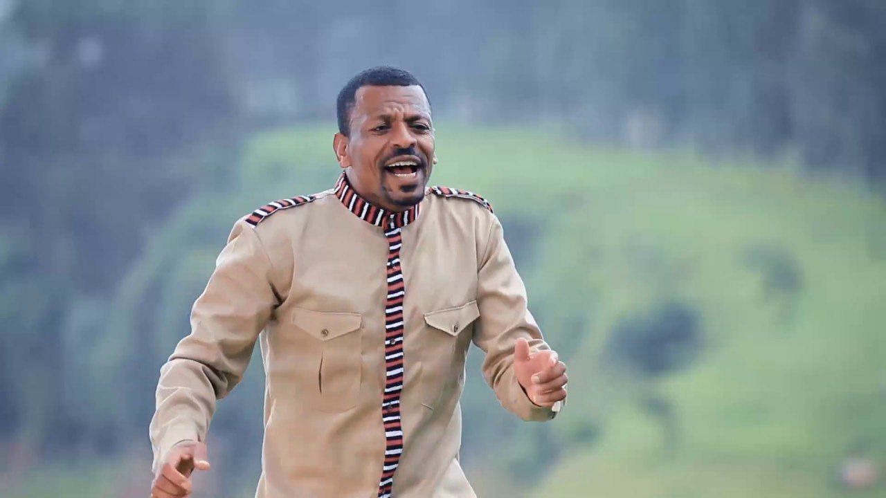 a man in a beige suit and striped tie running through the grass